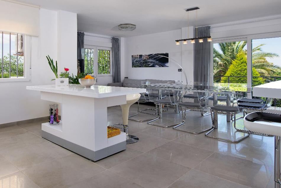 Cocina abierta con isla y comedor de la villa